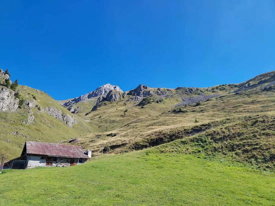 Schulausflug: Alphütte vor Bergkulisse bei blauem Himmel